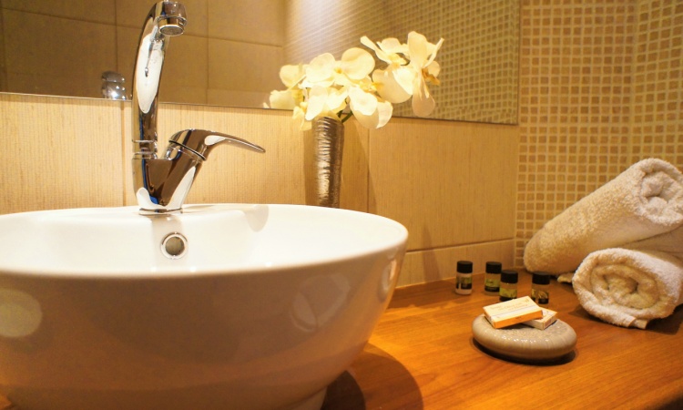Modern Bathroom Elegant bathroom with sink, mirror and flower decor at IDI Hotel