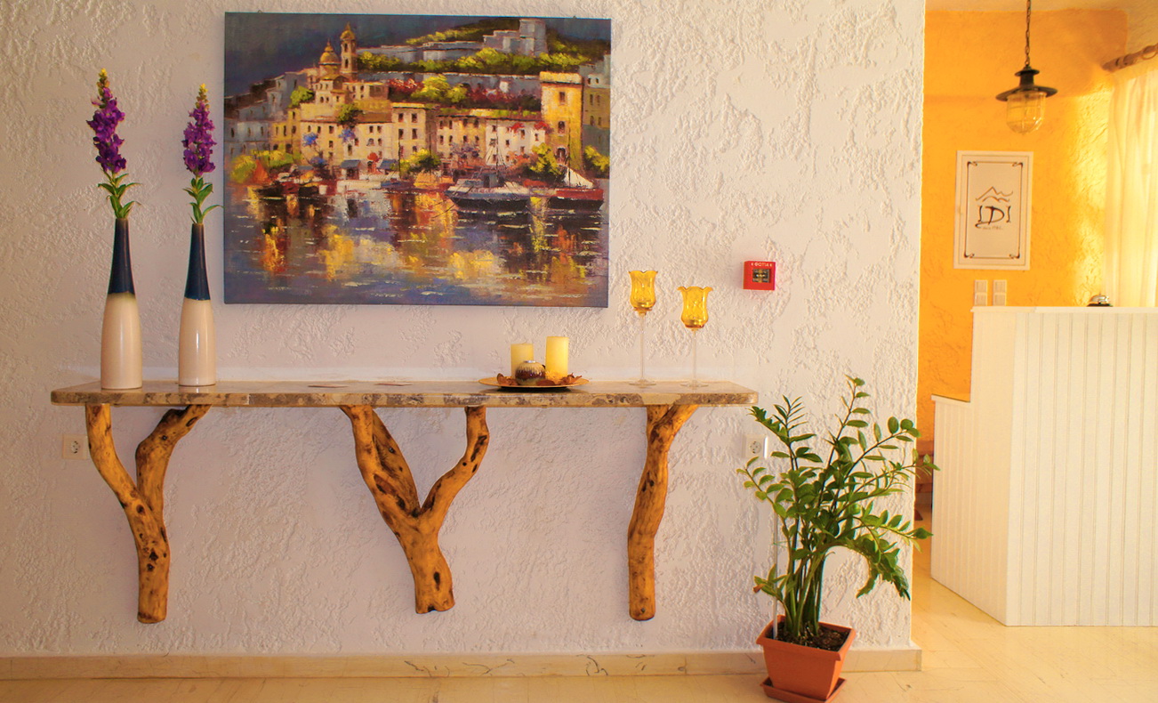 Decorative wooden console and wall art at the reception of IDI Hotel