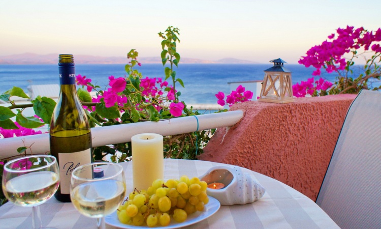 Sunset Moment Balcony table with wine and grapes overlooking the sea at sunset